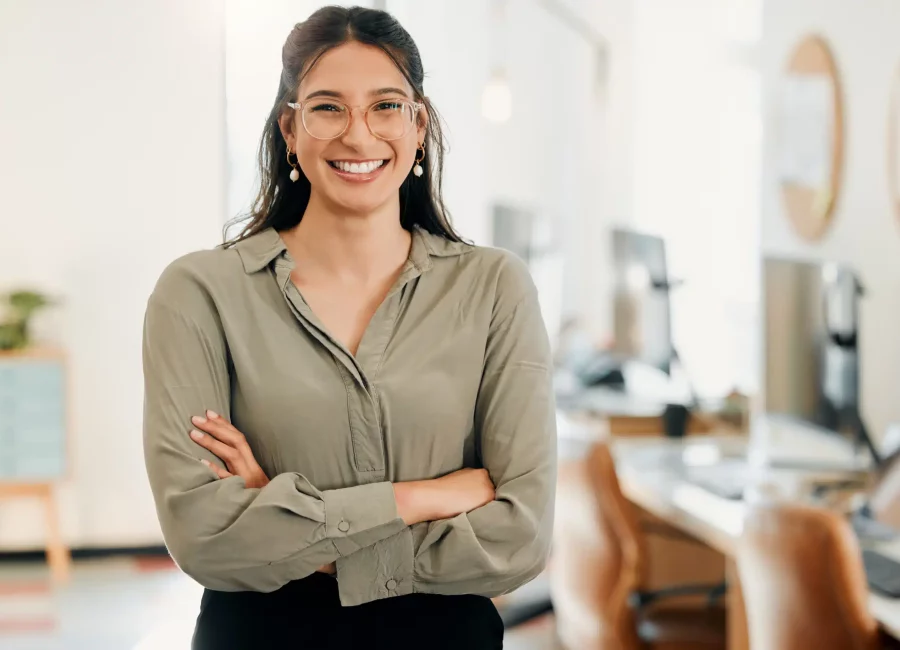 Confident young woman with glasses smiling in an office setting, showing healthy gums after Periodontal Therapy at Gridley Dental.